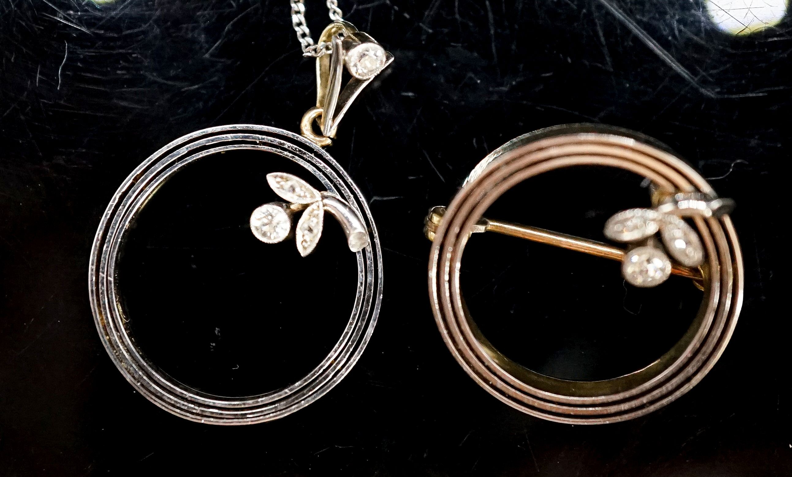 An early 20th century 15ct open work circular brooch with diamond set small flower and a matching pendant
